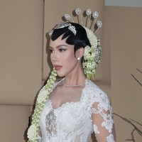 Kebaya dipadukan dengan kain batik cokelat bermotif klasik yang elegan. Kontras warna putih dan cokelat menciptakan harmoni adat Jawa yang kuat, diperindah dengan stagen hijau zamrud bermotif emas sebagai aksen pinggang. Foto: Instagram/@rhay_david