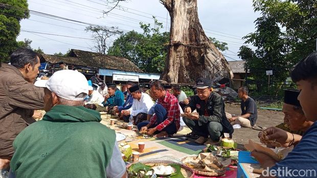 Warga menggelar selamatan di bawah pohon randu alas di Desa Tuksongo, Kecamatan Borobudur, Kabupaten Magelang, yang akan ditebang, Senin (12/1/2026).