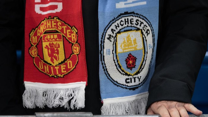 MANCHESTER, ENGLAND - DECEMBER 15: The club badges of Manchester City and Manchester United on a fans scarf during the Premier League match between Manchester City FC and Manchester United FC at Etihad Stadium on December 15, 2024 in Manchester, England. (Photo by Visionhaus/Getty Images)