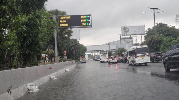 Genangan air di Tol Sedyatmo arah Bandara Soekarno-Hatta belum surut, Selasa (13/1/2026) pagi.