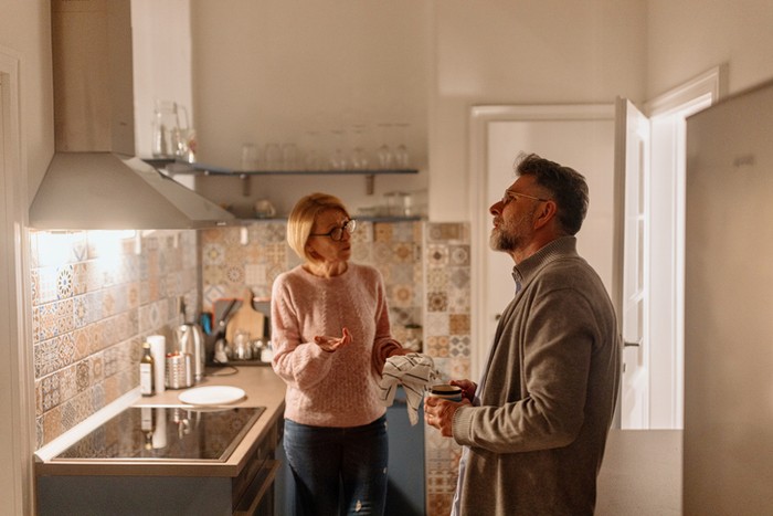 Ilustrasi istri dan suami masak di dapur.