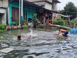 Pegangsaan Dua Jakut Masih Banjir, Jadi Wahana Bermain Dadakan Anak-anak