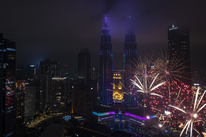 KUALA LUMPUR, MALAYSIA - JANUARY 01: Fireworks light up the sky as the Petronas Twin Towers are seen during New Year celebrations at Imperial Lexis Kuala Lumpur on January 01, 2026 in Kuala Lumpur, Malaysia. (Photo by Annice Lyn/Getty Images)