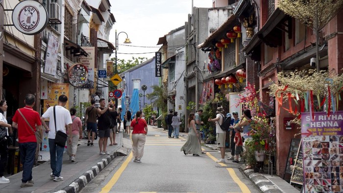 GEORGETOWN, PENANG, MALAYSIA - 2025/04/21: People walk down a street in Georgetown, Malaysia. George Town is a UNESCO World Heritage Site known for its rich cultural heritage and diverse architecture, attracting tourists with its unique blend of hist