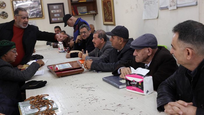 A participant calls out a bid during a weekly auction for collectors of coins and postage stamps in Baghdad, Iraq, January 10, 2026. Under Iraqi antiquities law, items older than 200 years cannot be sold and must be handed to the Ministry of Culture, Tourism and Antiquities. These old coins are traded at varying prices among collectors. REUTERS/Ahmed Saad