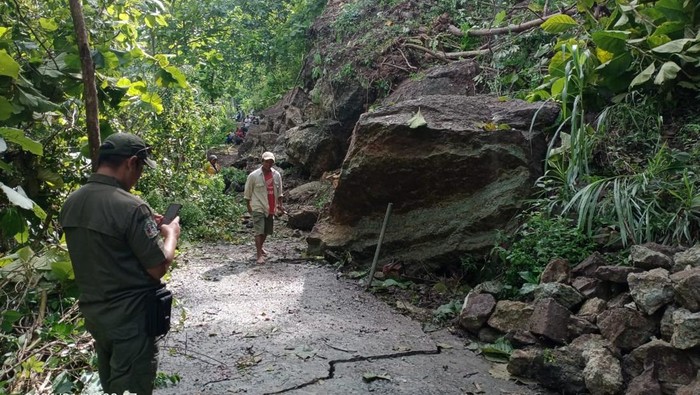 Tanah longsor yang menyebabkan batu berukuran besar menutup jalan penghubung Pedukuhan Krinjing-Gandu, Mertelu, Gedangsari, Gunungkidul, Selasa (13/1/2026).
