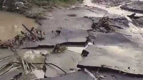 Aspal jalan pariwisata Selong Belanak-Kuta mengelupas dan berlumpur akibat banjir.