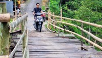 Struktur jembatan dilaporkan rusak parah akibat lapuk dan tergerus air hujan, sehingga hanya menyisakan jalur sempit selebar sekitar 20 sentimeter.