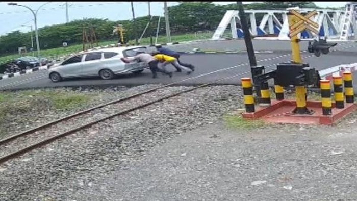 Kabid Humas Polda Jateng, Kombes Artanto, saat mendorong satu unit mobil mogok di tengah rel KA sehingga selamat dari kecelakaan di Jalan Madukoro Raya, Kota Semarang.