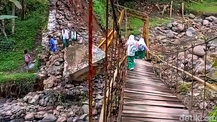 Sejumlah pelajar Sukabumi melintas di jembatan gantung miring.