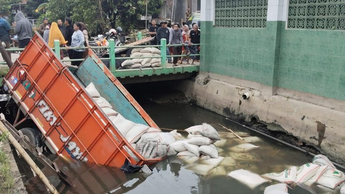 Truk pengangkut beras masuk ke sungai di Jalan Kaligawe, Kecamatan Genuk, Kota Semarang, Rabu (14/1/2026).