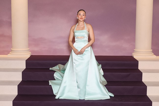 Yerin Ha memancarkan pesona putri dari negeri dongeng dalam balutan gaun Prada berwarna biru mint. Gaun Prada tanpa lengan ini memiliki garis leher halter dan detail cut-out kecil di bawah dada, yang dipertegas dengan hiasan kristal berkilau yang juga menghiasi bagian tali. Rok gaun yang bervolume menjuntai dramatis. Foto: Getty Images/Stephane Cardinale