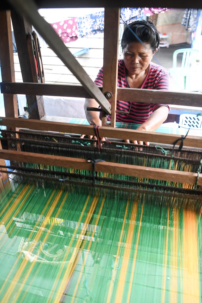 Perajin menyelesaikan pembuatan tenun menggunakan alat tenun bukan mesin (ATBM) di Kampung Tenun, Samarinda Seberang, Kota Samarinda, Kalimantan Timur, Rabu (14/1/2026). Menurut Kepala Bidang Kebudayaan Dinas Pendidikan dan Kebudayaan (Disdikbud) Kota Samarinda Barlin Hady Kesuma, bahwa 120 penenun aktif di Kampung Tenun Samarinda Seberang tersebut masih kesulitan bahan baku berupa benang sutra untuk memproduksi sarung tenun kategori premium guna melestarikan sarung tenun Samarinda sebagai salah satu khazanah budaya di Kalimantan Timur. ANTARA FOTO/M Risyal Hidayat/YU