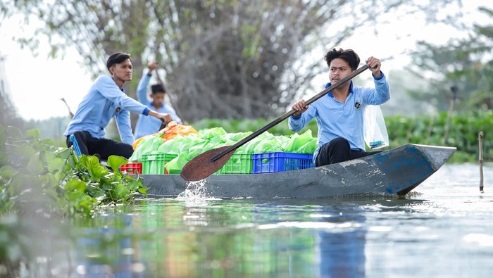Petugas Satuan Pelayanan Pemenuhan Gizi (SPPG) Dapur Carnis mendistribusikan bingkisan Makanan Bergizi Gratis (MBG) menggunakan perahu di Deket, Lamongan, Jawa Timur, Kamis (15/1/2026). Petugas SPPG setempat menyalurkan sebanyak 600 bingkisan MBG untuk 35 sekolah dan ibu hamil menggunakan perahu di tujuh desa yang terdampak banjir luapan Sungai Bengawan Jero. ANTARA FOTO/Rizal Hanafi