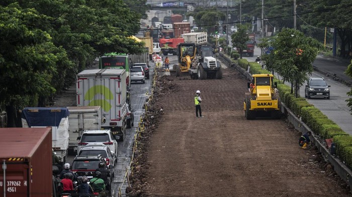 Pekerja memadatkan tanah menggunakan alat berat dalam proyek peninggian Jalan Pantura Kaligawe Raya di Semarang, Jawa Tengah, Kamis (15/1/2026). Balai Besar Pelaksanaan Jalan Nasional (BBPJN) Jateng-DIY Kementerian Pekerjaan Umum melakukan proyek peninggian jalan pada KM 3+900 hingga KM 4+600 jalur utama pantura Semarang-Surabaya untuk meningkatkan kapasitas jalan serta mengantisipasi genangan dan banjir rob akibat penurunan muka tanah yang ditargetkan selesai pada Maret 2026. ANTARA FOTO/Aprillio Akbar