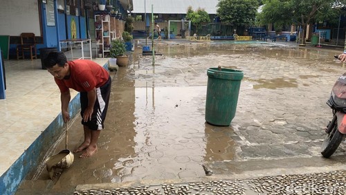 Para guru membersihkan sisa-sisa lumpur sedimentasi di halaman SDN 01 Sekotong Tengah, seusai dilanda banjir, Kamis (15/01/2026).