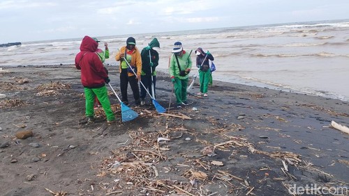 Sejumlah petugas membersihkan sampah kiriman di Pantai Cemagi, Kecamatan Mengwi, Badung, Bali, Kamis (15/1/2026). (Foto: Agus Eka/detikBali)