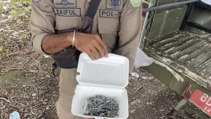 Seorang petugas Satpol PP Sidoarjo menunjukkan hasil penyisiran ranjau paku di kawasan lingkar timur yang sempat viral di medsos.