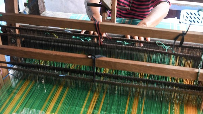 Perajin menyelesaikan pembuatan tenun menggunakan alat tenun bukan mesin (ATBM) di Kampung Tenun, Samarinda Seberang, Kota Samarinda, Kalimantan Timur, Rabu (14/1/2026). Menurut Kepala Bidang Kebudayaan Dinas Pendidikan dan Kebudayaan (Disdikbud) Kota Samarinda Barlin Hady Kesuma, bahwa 120 penenun aktif di Kampung Tenun Samarinda Seberang tersebut masih kesulitan bahan baku berupa benang sutra untuk memproduksi sarung tenun kategori premium guna melestarikan sarung tenun Samarinda sebagai salah satu khazanah budaya di Kalimantan Timur. ANTARA FOTO/M Risyal Hidayat/YU