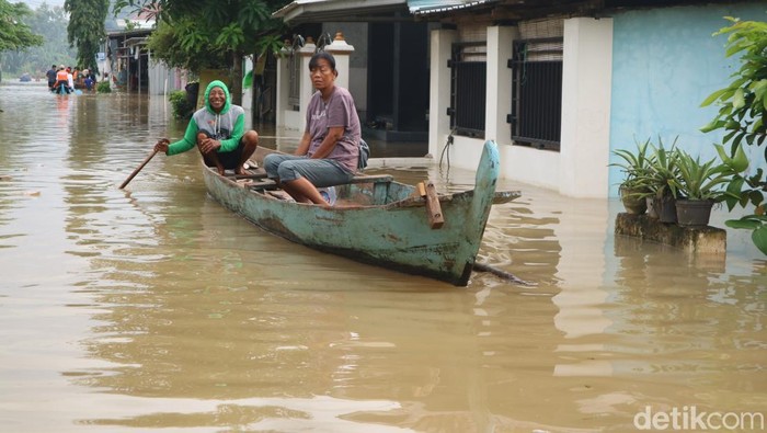 Aktivitas warga menggunakan perahu karena genangan banjir tinggi di Dukuh Ngantru Desa Mustokoharjo Kecamatan Pati, Jumat (16/1/2026).