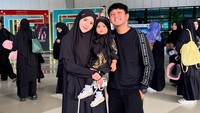 Bella Bonita berpenampilan hijab dengan pakaian panjang berwarna hitam sambil menggendong anaknya, Cunda, yang berpakaian sama. Ia tampak berada di bandara bersama suaminya, Denny Caknan. (Foto: dok Instagram denny_caknan)
