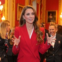 Kate tampil percaya diri mengenakan setelan jas merah terang rancangan Alexander McQueen. Busana tersebut terdiri dari blazer berkancing asimetris dan celana panjang berpotongan wide-leg.  (Foto: Kin Cheung/WPA Pool/Getty Images)