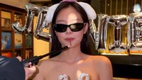 Jennie BLACKPINK memegang kue ulang tahun berbentuk Cinnamoroll sambil dipakaikan kacamata. Ia juga lagi menggigit lilin yang hendak disulutkan api. (Foto: dok Instagram jennierubyjane)