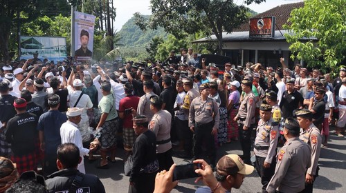 Polisi berjaga-jaga saat terjadi aksi saling dorong dalam upacara pecaruan di Desa Adat Bugbug, Karangasem Jumat (16/1/2026).
