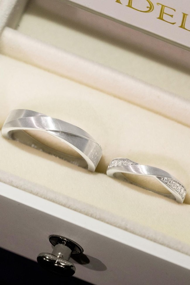 Pada cincin pengantin wanita, setengah bagian band dihiasi barisan berlian kecil yang tersusun presisi, menghasilkan kilau lembut tapi konsisten dari berbagai sudut. Sentuhan geometris modern berpadu dengan proporsi seimbang, menciptakan tampilan yang tak lekang oleh waktu. (Foto: Dok. Adelle Jewelry)