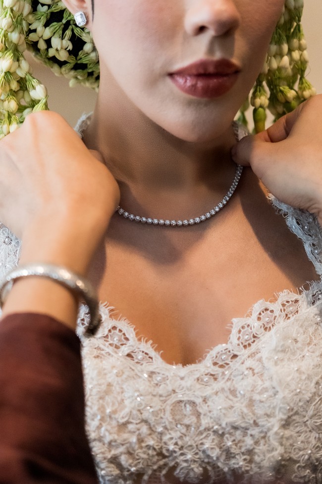 Ia memilih Lexicon of Diamond Necklace sebagai statement utama, menampilkan rangkaian berlian signature Eternal Flame dengan performa pantulan cahaya tinggi. Kilau berlian tersebut menyatu harmonis dengan kebaya putih yang dikenakannya, menghadirkan kesan mewah tanpa berlebihan. (Foto: Dok. Adelle Jewelry)