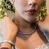 Ia memilih Lexicon of Diamond Necklace sebagai statement utama, menampilkan rangkaian berlian signature Eternal Flame dengan performa pantulan cahaya tinggi. Kilau berlian tersebut menyatu harmonis dengan kebaya putih yang dikenakannya, menghadirkan kesan mewah tanpa berlebihan. (Foto: Dok. Adelle Jewelry)