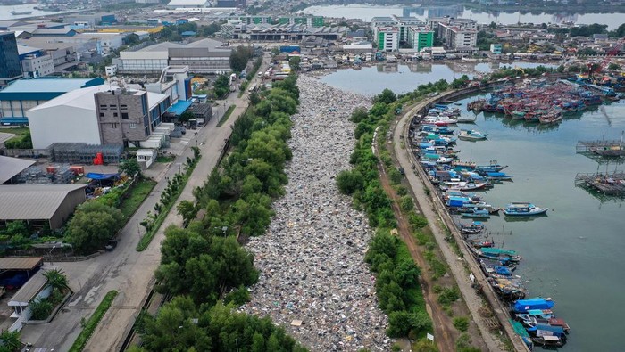 Foto udara petugas mengangkut sampah di kawasan Muara Baru, Jakarta, Jumat (16/1/2026). Sebanyak 120 personel Dinas Lingkungan Hidup DKI Jakarta dikerahkan untuk membersihkan sampah rumah tangga di permukaan air laut yang diduga berasal dari tempat pembuangan sampah (TPS) ilegal di kawasan tersebut. ANTARA FOTO/Sulthony Hasanuddin/bar