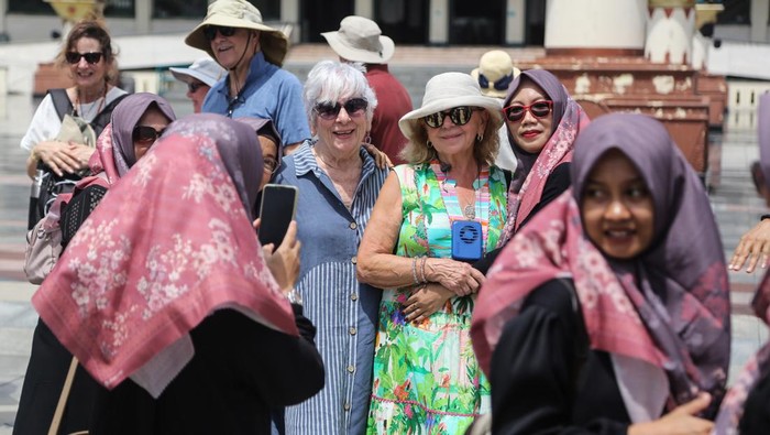 Wisatawan mancanegara berfoto dengan wisatawan domestik saat berkunjung di Masjid Agung Jawa Tengah (MAJT), Semarang, Jawa Tengah, Jumat (16/1/2026). Sebanyak 1.000 lebih wisatawan mancanegara dari kapal pesiar Ocean Regatta dan Ocean Sirena yang berlabuh di Pelabuhan Tanjung Emas tersebut mengunjungi sejumlah obyek wisata unggulan di Kota Semarang seperti MAJT, Sam Poo Kong, Cagar Budaya Nasional Kota Lama dan wisata kuliner untuk mengenal sejarah serta perkembangan budaya khas Indonesia. ANTARA FOTO/Makna Zaezar/bar