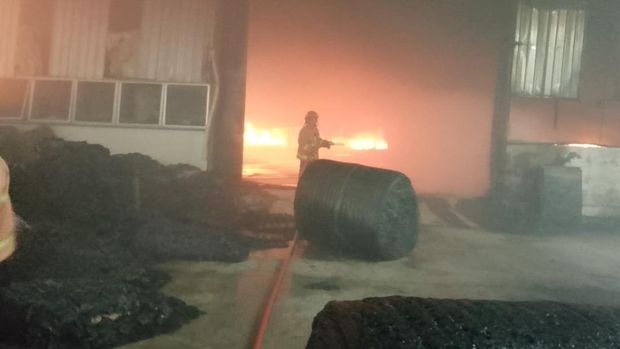 Petugas pemadam kebakaran saat berusaha menjinakkan api yang melahap pabrik busa di Desa Pringtulis, Nalumsari, Jepara, Sabtu (17/1/2026).