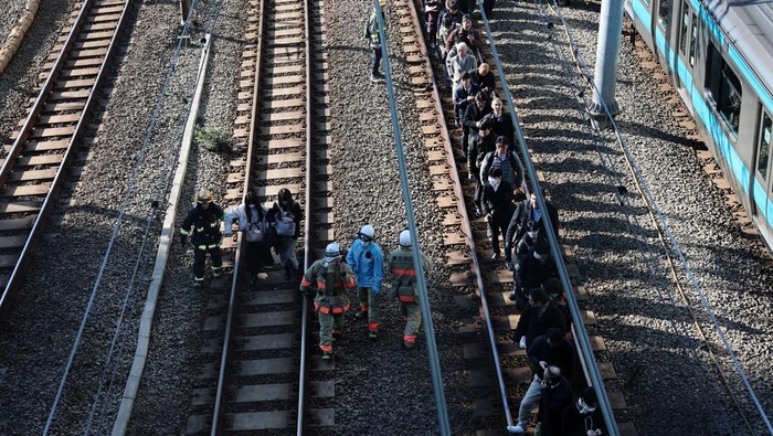 Passengers evacuated from a stranded train on Keihin-Tohoku line walk to Tamachi station in Tokyo, Japan, January 16, 2026. REUTERS/Kim Kyung-Hoon
