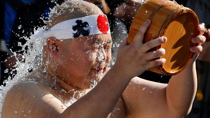 Men splash themselves with cold water during the annual cold water endurance ceremony to purify their souls and wish for good fortune in the new year, at the Kanda Myojin shrine in Tokyo, Japan, January 17, 2026. REUTERS/Kim Kyung-Hoon