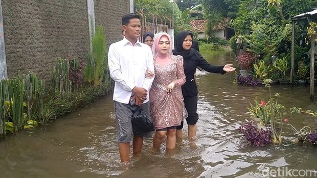 Pengantin naik perahu karet di Desa Sepacar, Kecamatan Tirto, Kabupaten Pekalongan, Minggu (18/1/2026).