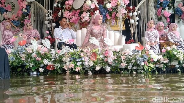 Pengantin naik perahu karet di Desa Sepacar, Kecamatan Tirto, Kabupaten Pekalongan, Minggu (18/1/2026).