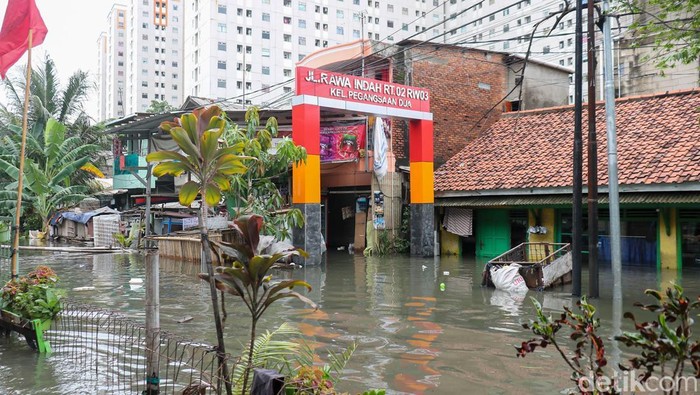 Banjir kembali menggenangi permukiman Rawa Indah, Pegangsaan Dua, Jakarta Utara, Minggu (18/1/2026). Genangan setinggi 35–75 cm membuat aktivitas warga terganggu.