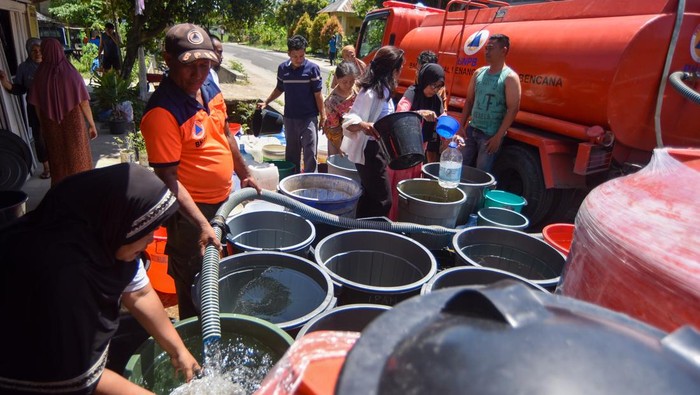 Petugas BPBD Padang mengisi air bersih ke ember milik warga di Vila Tarok, Pasa Ambacang, Kuranji, Padang, Sumatera Barat, Minggu (18/1/2026). Dua wilayah kecamatan yaitu Pauh dan Kuranji mengalami krisis air bersih akibat mengeringnya sumur serta rusaknya bendungan dan irigasi pascabencana November 2025 sehingga masyarakat setempat bergantung pada suplai air bersih dari berbagai pihak. ANTARA FOTO/Iggoy el Fitra/nym.