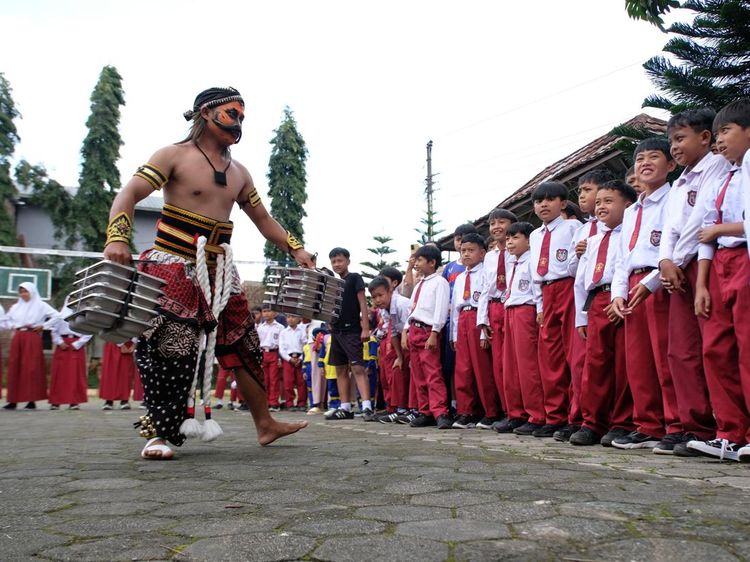 Aksi Unik Relawan Berbusana Warokan Bagikan Makan Bergizi di Sekolah