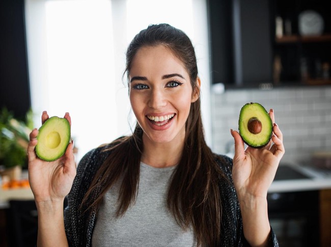 Ilustrasi wanita memegang alpukat.