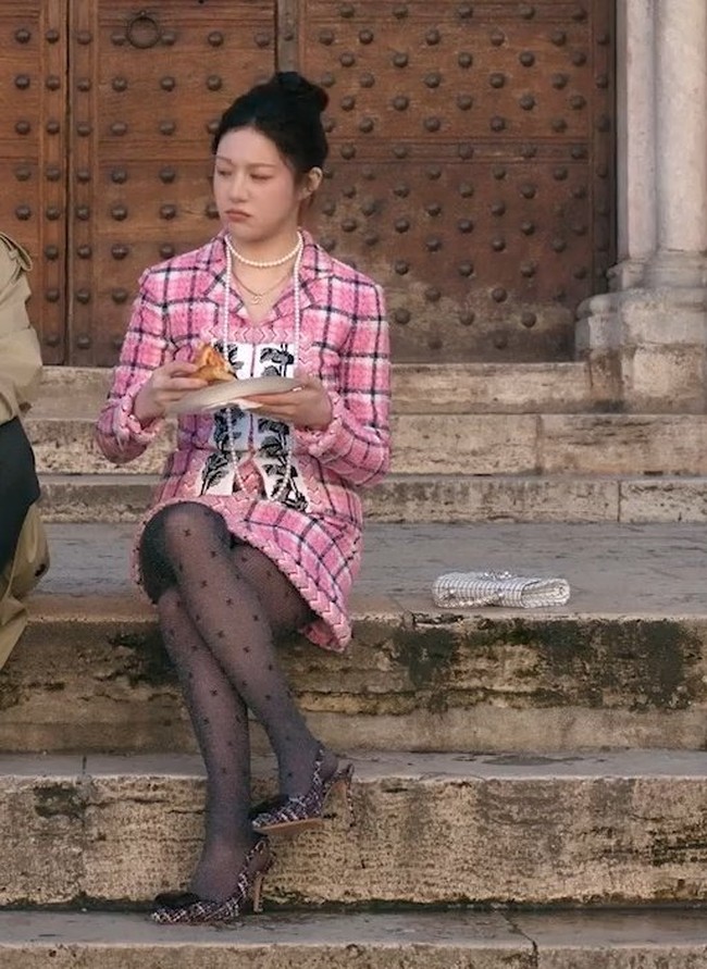 The real Princess Chanel. Go Youn Jung terlihat ‘ngemper’ makan pizza bareng Kim Seon Ho di salah satu episode. Namun, set jaket dan rok tweed pink bermotif kotak-kotak yang dipakainya Chanel Spring/Summer 2024. Foto: Instagram