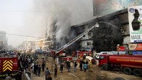 Petugas pemadam kebakaran berupaya menjinakkan api yang melalap bangunan bertingkat selama berjam-jam. Foto: REUTERS/Stringer