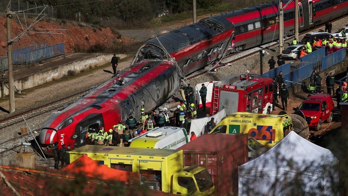 Members of the Spanish Civil Guard, along with other emergency personnel, work next to one of the trains involved in the accident, at the site of a deadly derailment of two high-speed trains near Adamuz, in Cordoba, Spain, January 19, 2026. REUTERS/Susana Vera     TPX IMAGES OF THE DAY