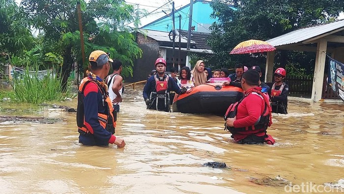 Petugas mengevakuasi korban banjir di Karawang
