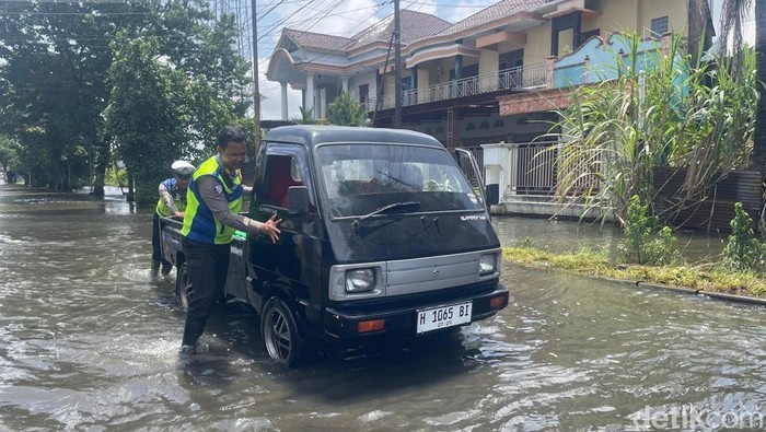 Polisi mendorong mobil mogok di jalur alternatif Kudus-Purwodadi,  Desa Tanjungkarang, Kecamatan Jati,  Kudus, Senin (19/1/2026).