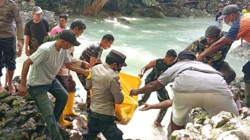 Polisi, tentara, dan warga mengevakuasi jenazah siswa SMP yang sebelumnya tenggelam di Air Terjun Tiwu Pai, Desa Toe, Kecamatan Reok Barat, Manggarai, NTT, Senin (19/1/2026). (Dok. Polsek Reo)