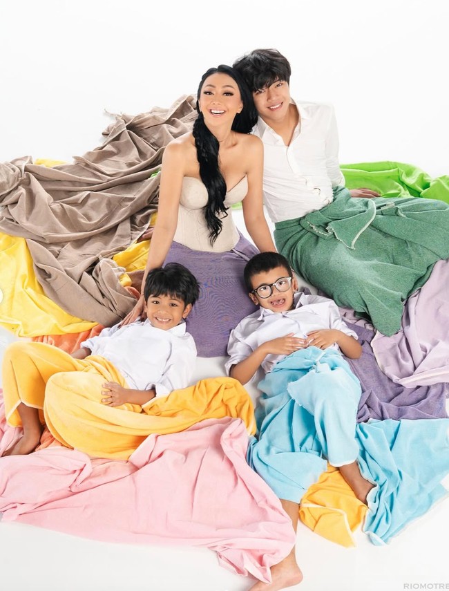 Riasan wajah Asri terlihat natural-glam dengan kulit yang tampak flawless, riasan mata lembut, serta lipstik bernuansa nude. Rambut panjangnya dibiarkan terurai dan ditata bergelombang. Foto: Instagram/@riomotret