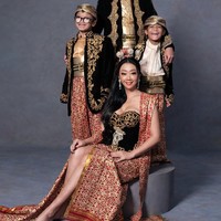 Sementara look kedua tampak bernuansa tradisional dengan balutan busana adat. Asri dan ketiga putranya tampil kompak dalam warna dominan merah, emas, dan hitam. Foto: Instagram/@riomotret
